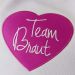 Pinkfarbenes Stoff-Herz mit Team Braut Stick auf Flieder-farbenem Beutel