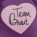 Rosafarbenes Herz-Bügelbild mit Team Braut Stick auf lilafarbenem Stoff